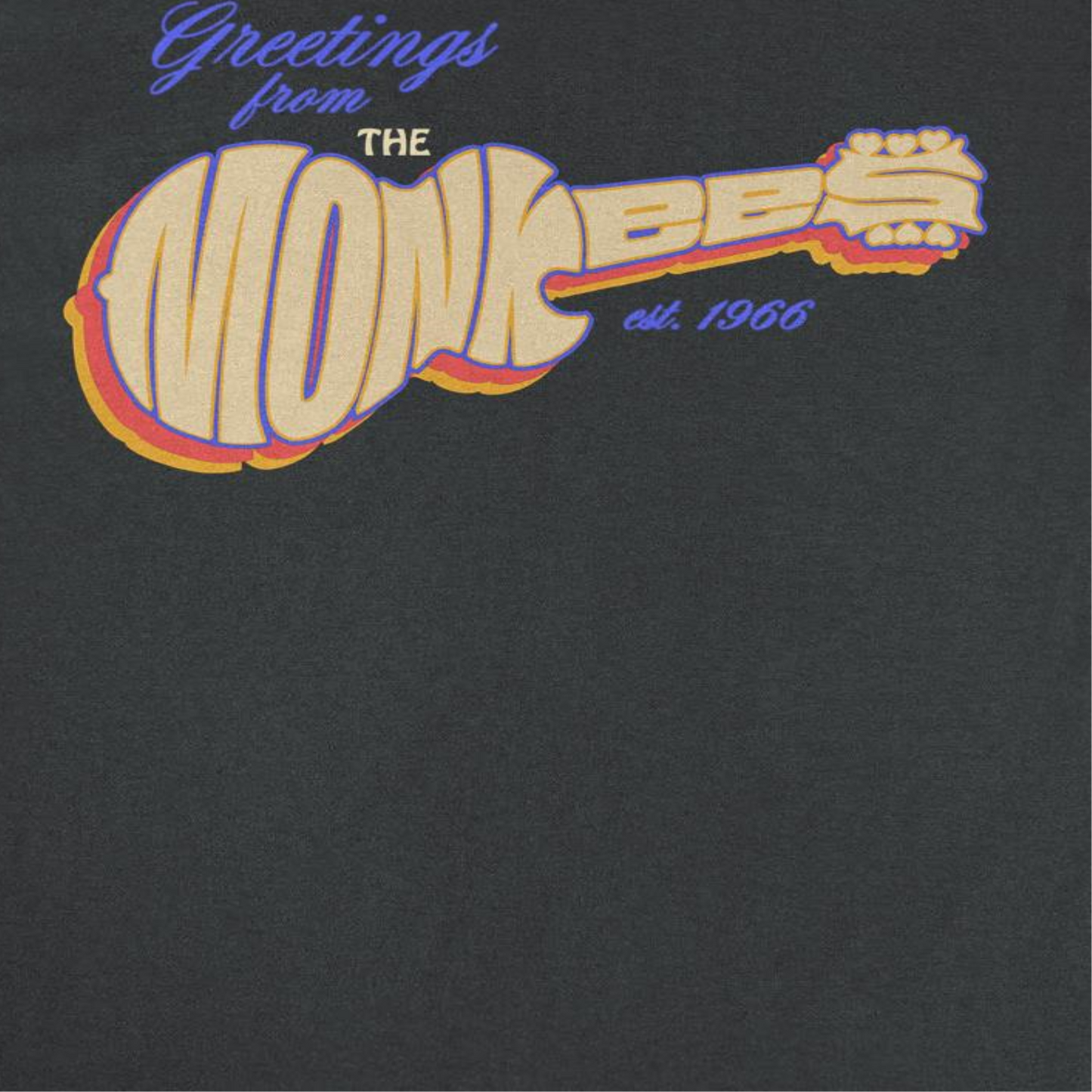 Close-up of The Monkees guitar logo graphic featuring retro 1960s pop-rock artwork on an officially licensed black band t-shirt