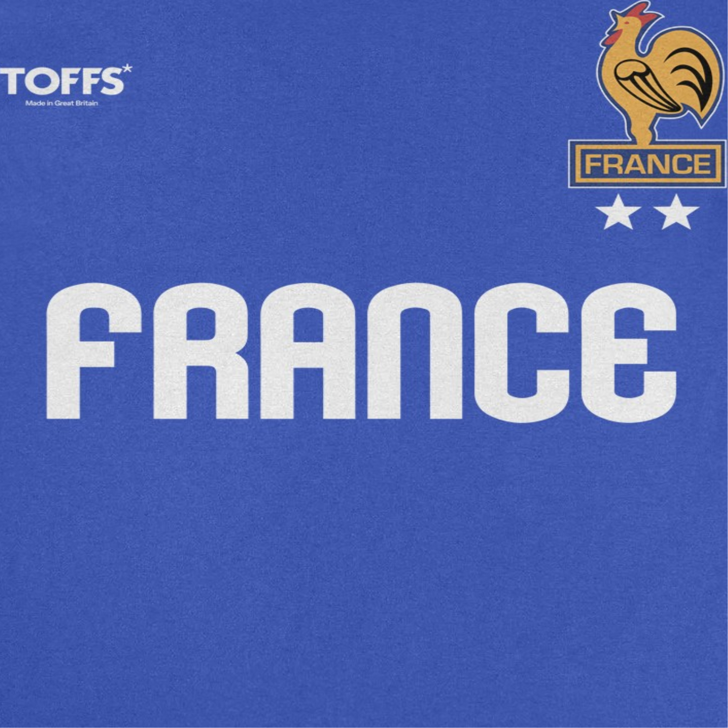 Close-up of Toffs Retro Soccer France royal blue t-shirt showing bold France lettering, rooster crest, and two-star futbol graphic