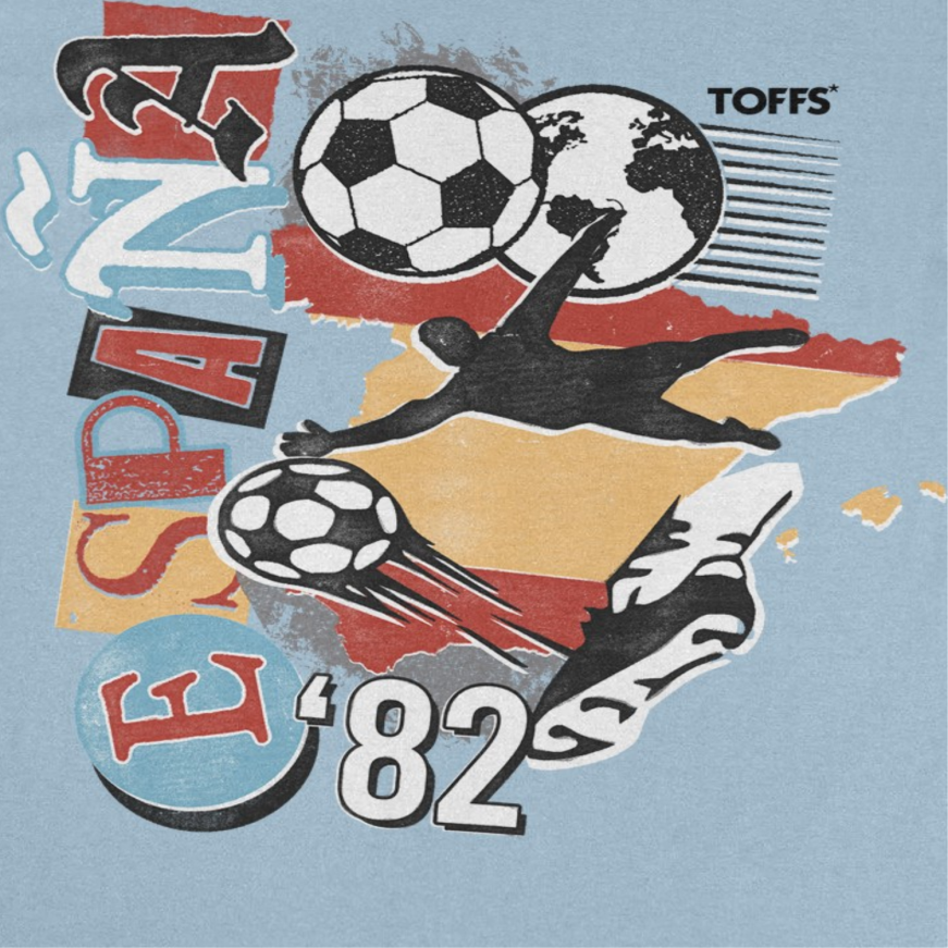 Close-up of Toffs Retro Soccer Spain Light Blue T-Shirt featuring España 82 futbol artwork, soccer ball graphics, globe detail, and vintage athletic design.