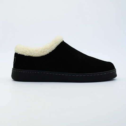Black slip-on shoe with white fur lining on a light gray background