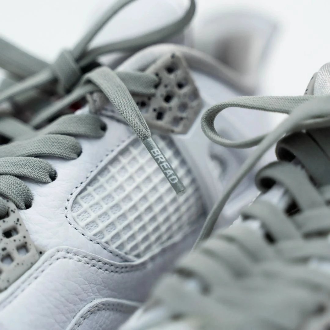 Close-up of gray sneakers with 'Bread' branding on a blurred background