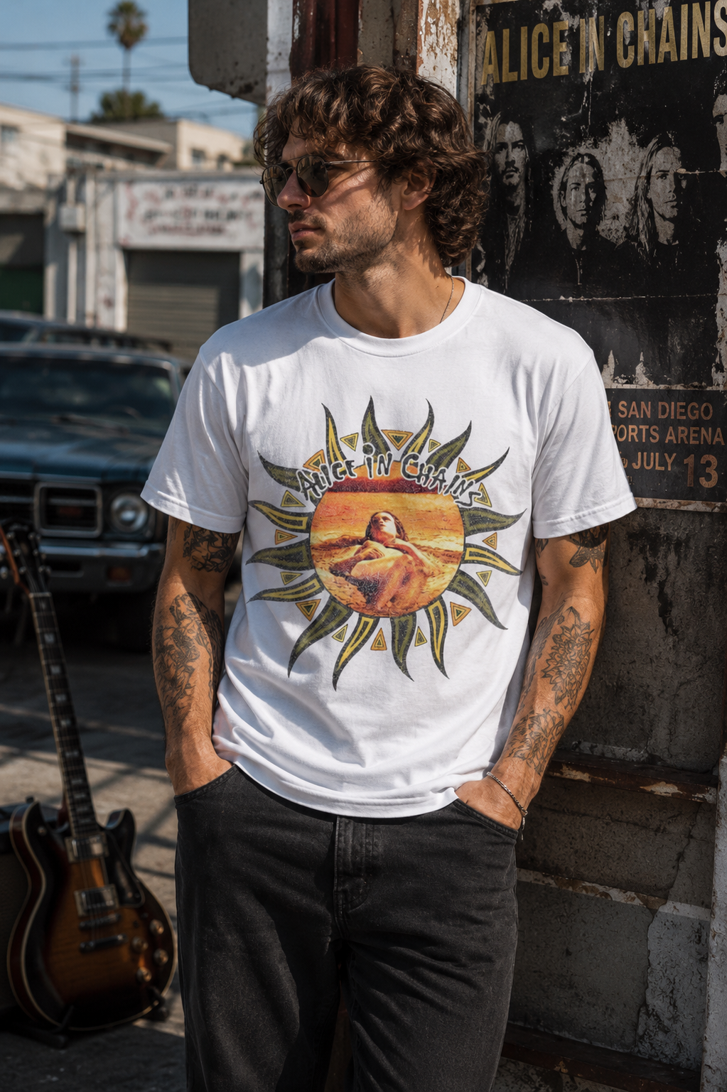 Male model wearing an officially licensed Alice in Chains Sunburst Logo White T-Shirt in an urban rock-inspired setting with vintage guitar, concert poster, and classic alternative rock atmosphere.