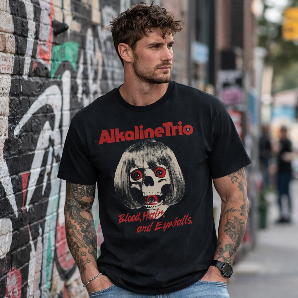 male model wearing Alkaline Trio Skelly Eyes black t shirt with skull graphic and red eyes design in urban street setting