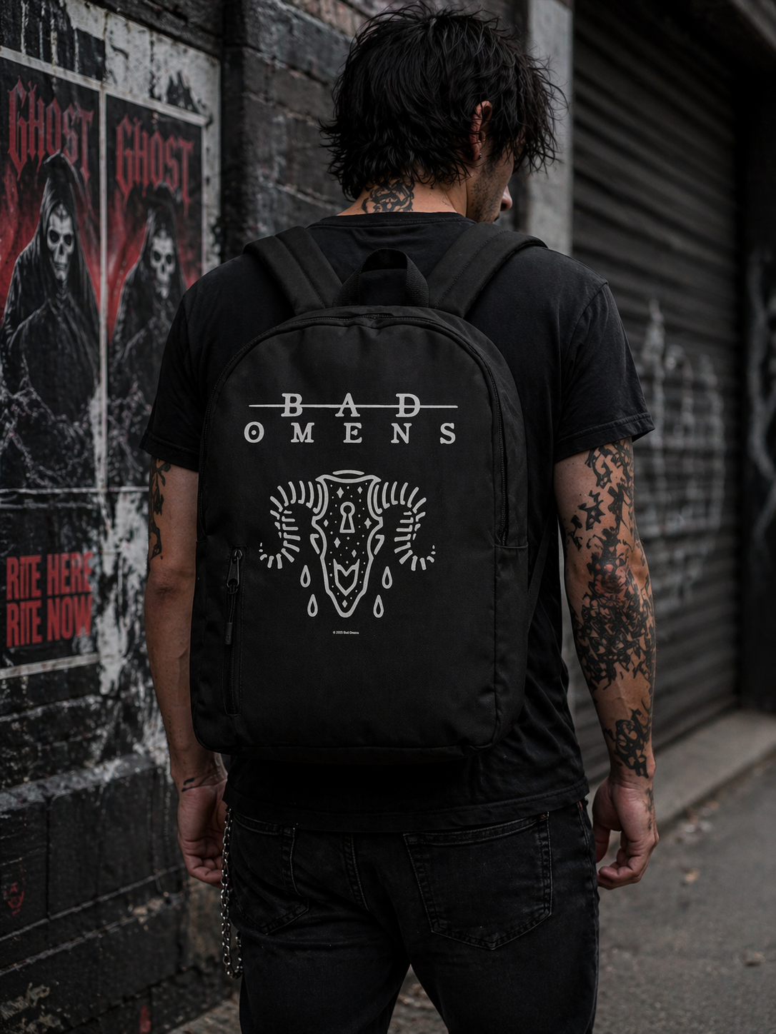 Male model wearing Bad Omens Ramskull backpack with minimalist skull design in urban setting