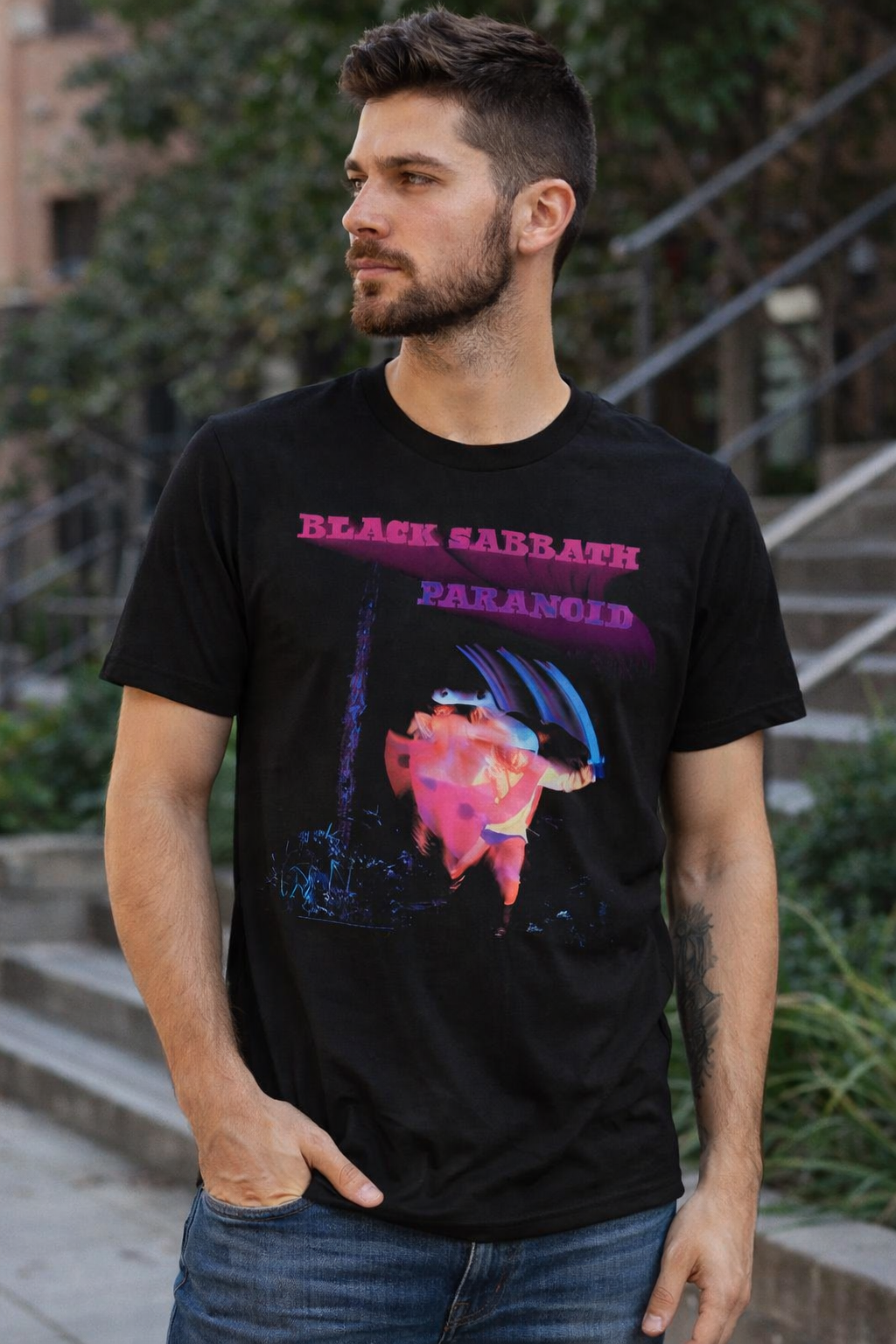 male model wearing Black Sabbath Paranoid t-shirt featuring iconic album artwork in casual streetwear setting