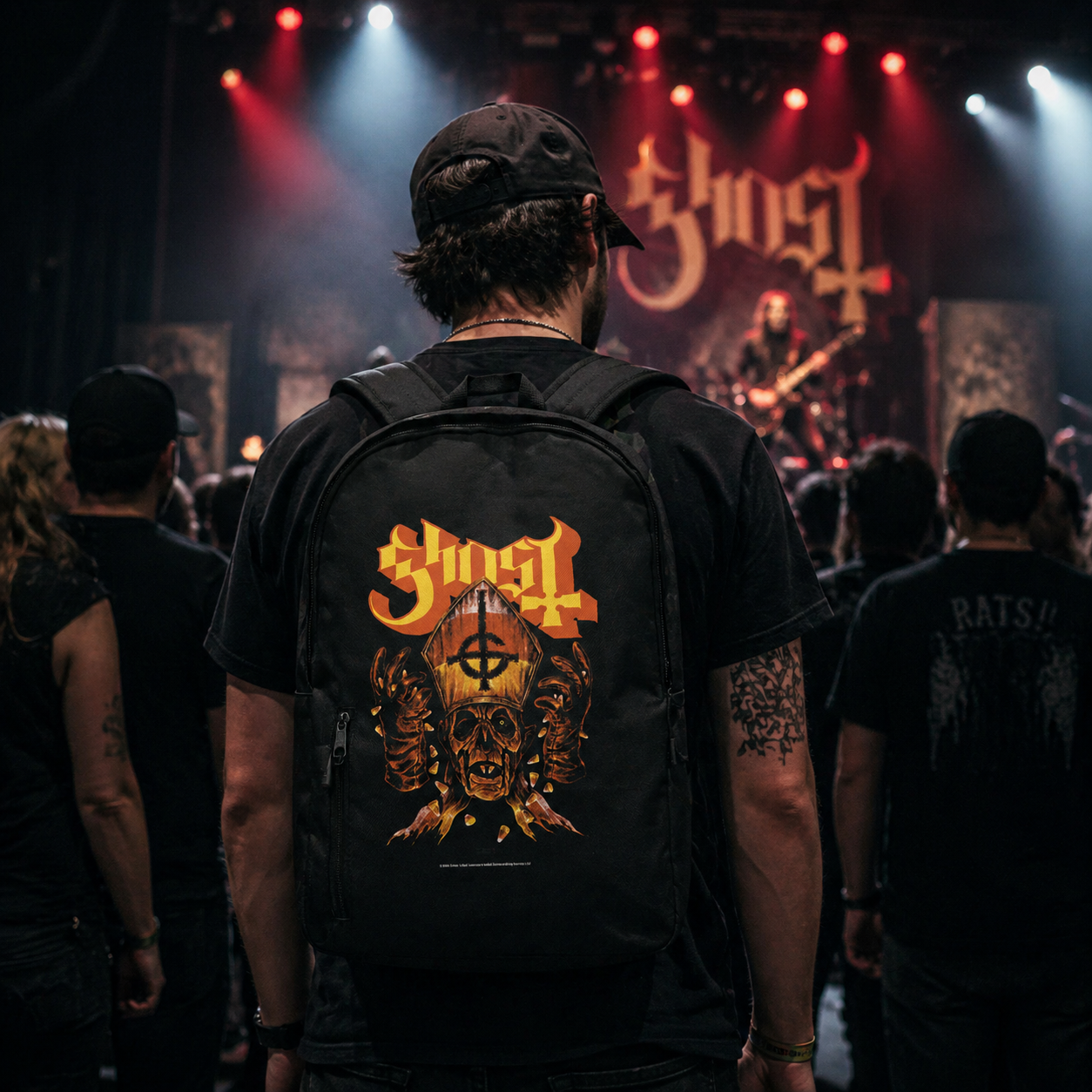 Male model wearing Ghost Candy Corn backpack at concert with crowd and stage lights metal band merch lifestyle image