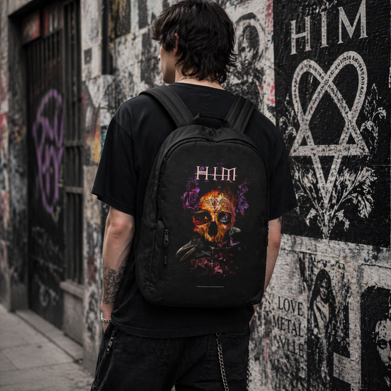 Male model wearing HIM Corpus backpack with skull artwork in urban street setting