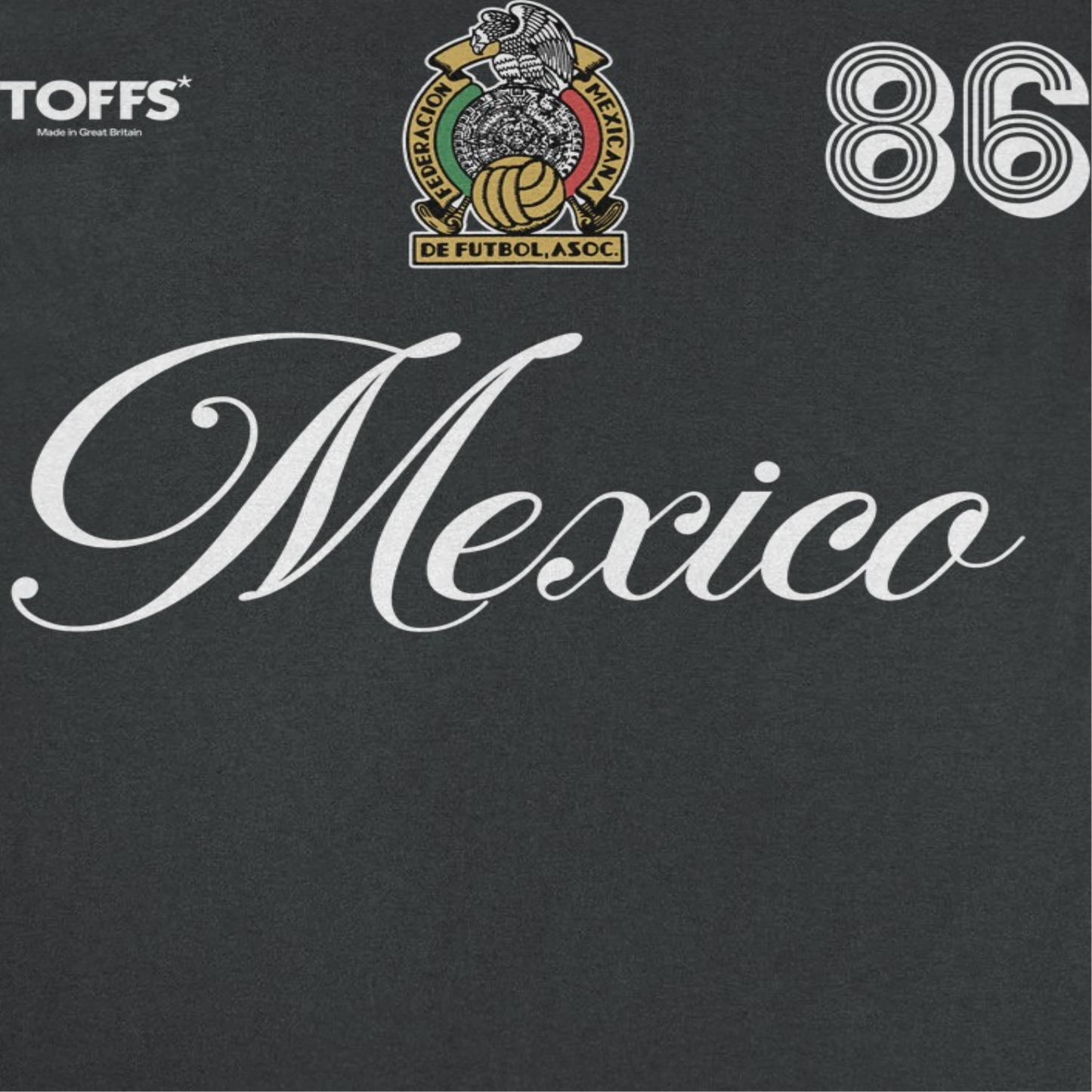 Close-up of Mexico black retro soccer t-shirt featuring white script lettering, crest artwork, and number 86 futbol design
