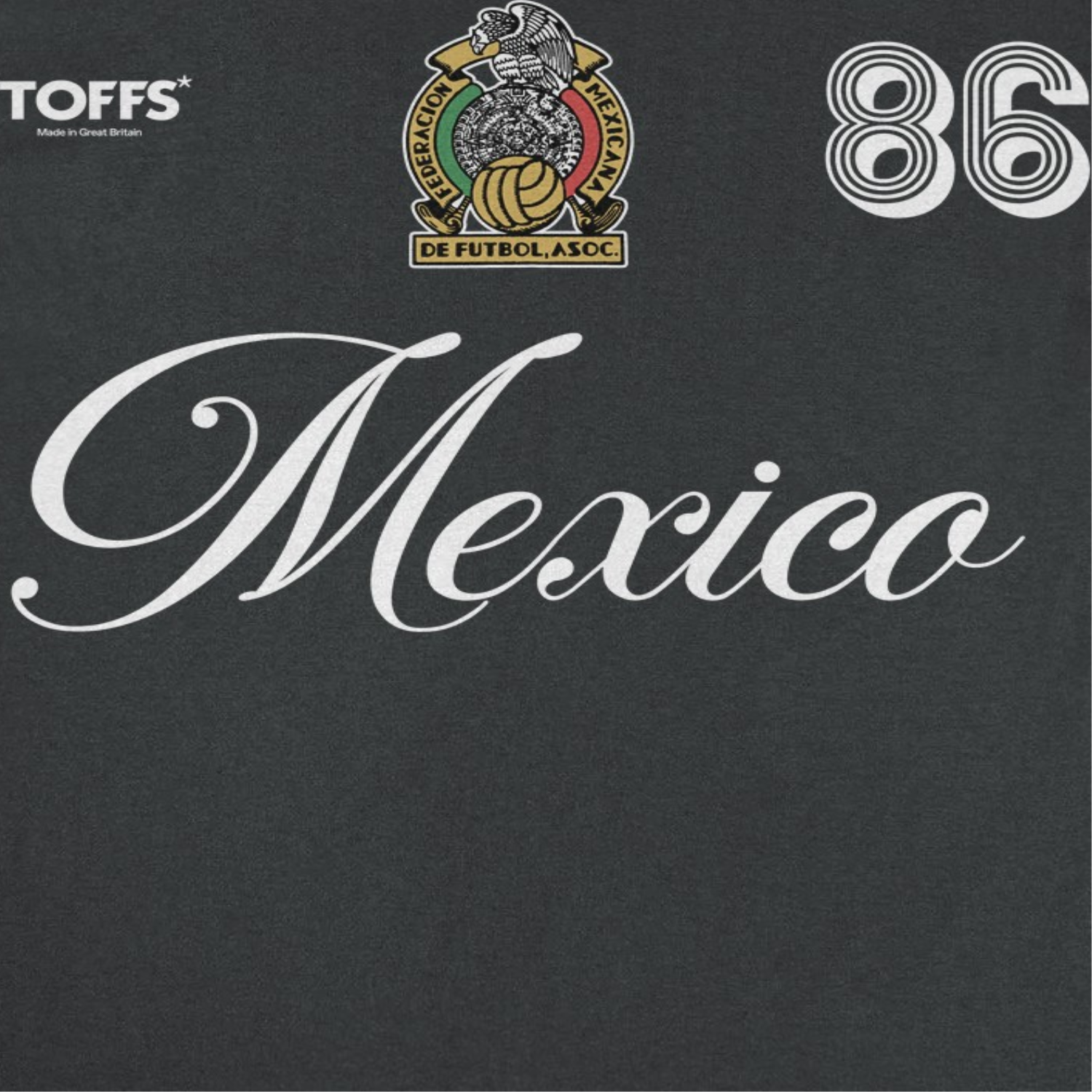 Close-up of Mexico black retro soccer t-shirt featuring white script lettering, crest artwork, and number 86 futbol design