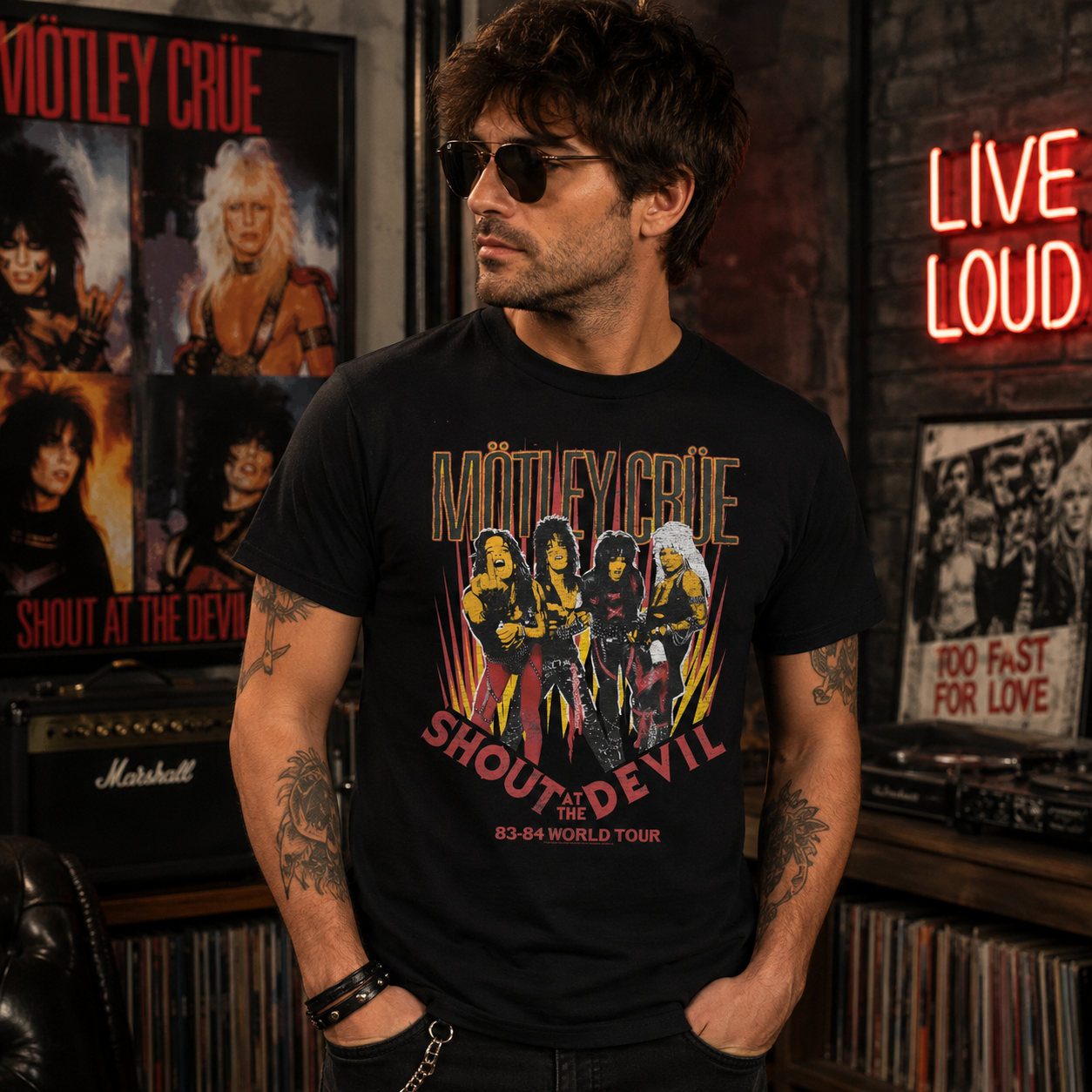 Male model wearing the officially licensed Mötley Crüe Shout at the Devil 83-84 World Tour black graphic T-shirt in a vintage rock music studio.