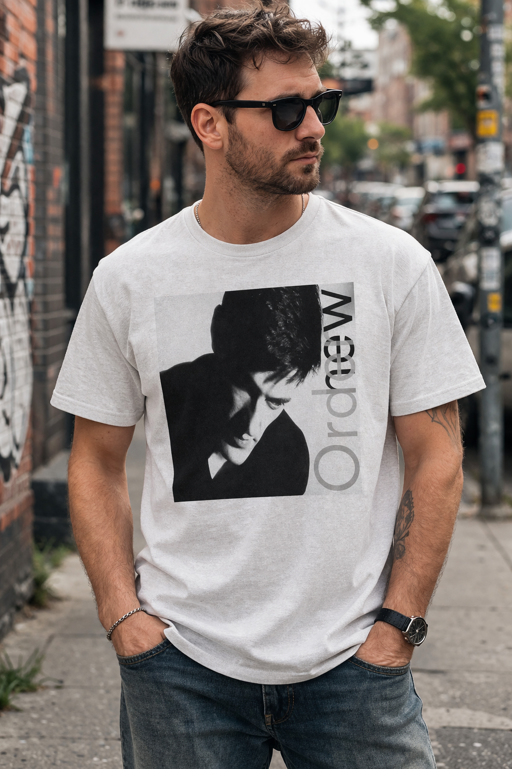 Male model wearing New Order Low-Life t shirt with 1985 album cover design in urban street setting casual outfit