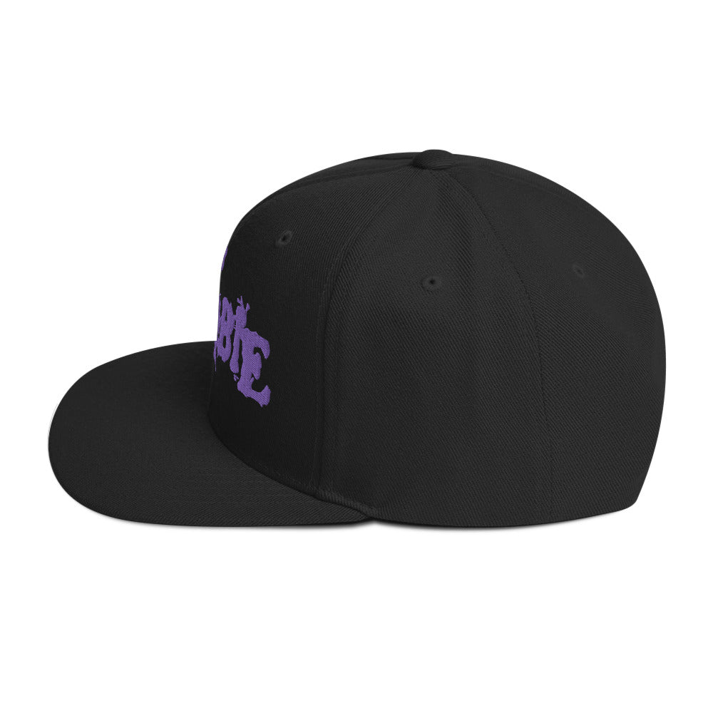 Side view of an official Rob Zombie logo snapback hat featuring a purple embroidered logo on a black adjustable cap.