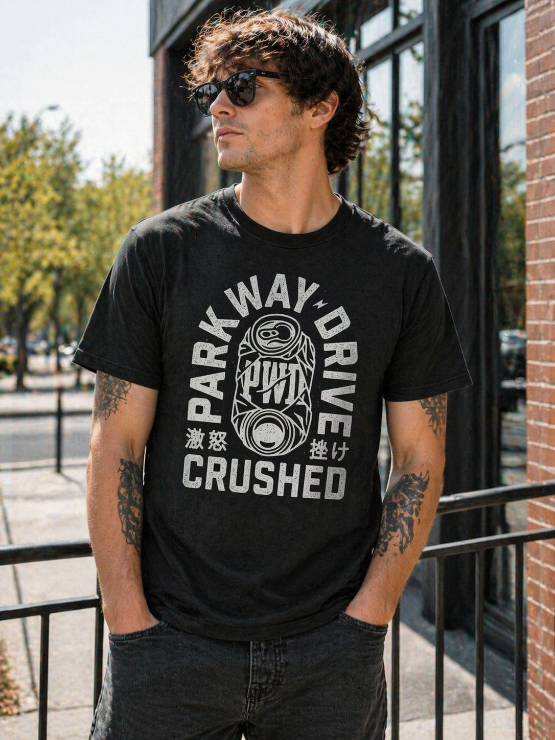 male model wearing Parkway Drive crushed can black t shirt in bright urban daylight setting metalcore band merch