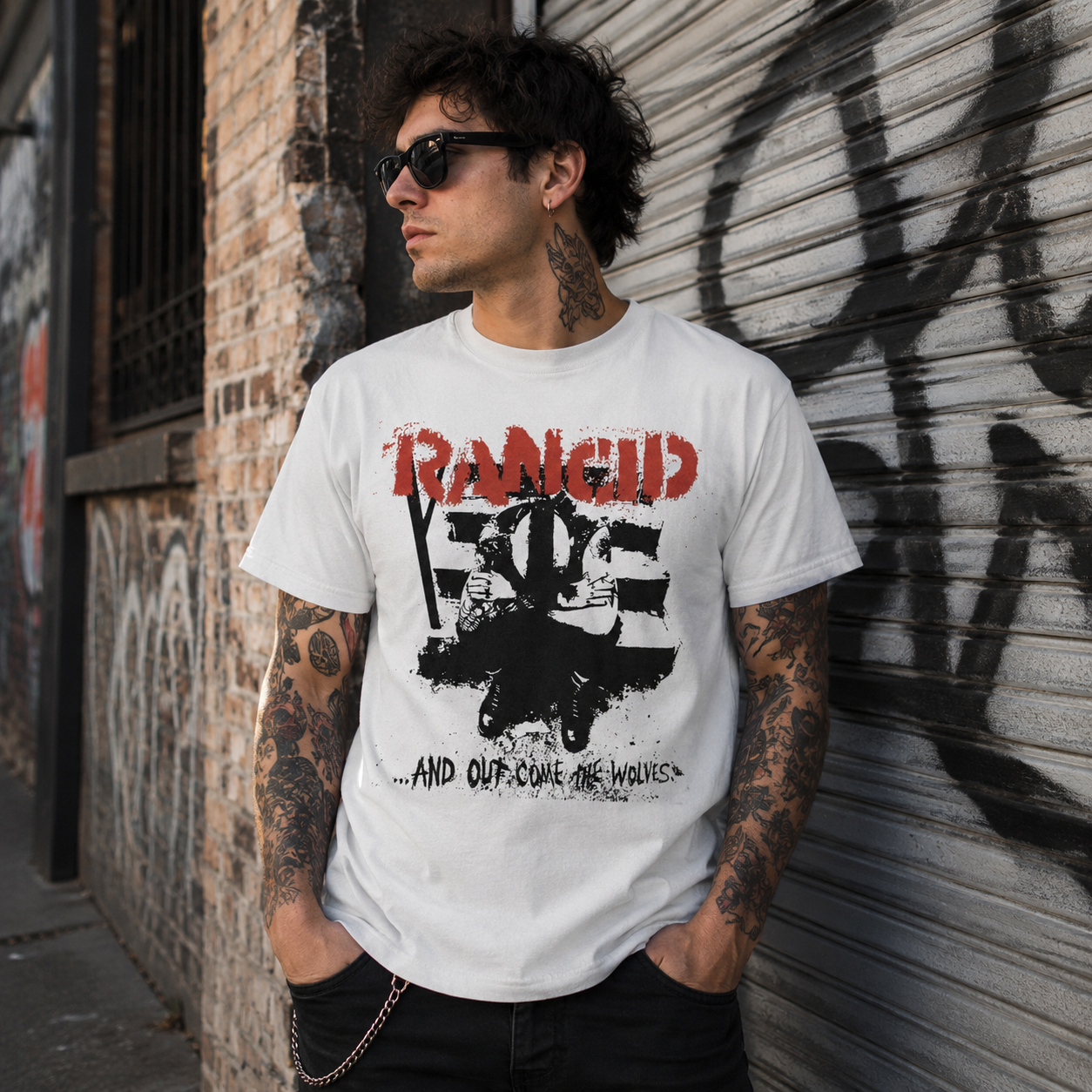 Male model wearing officially licensed Rancid And Out Come the Wolves punk band t-shirt in an urban graffiti streetwear setting.
