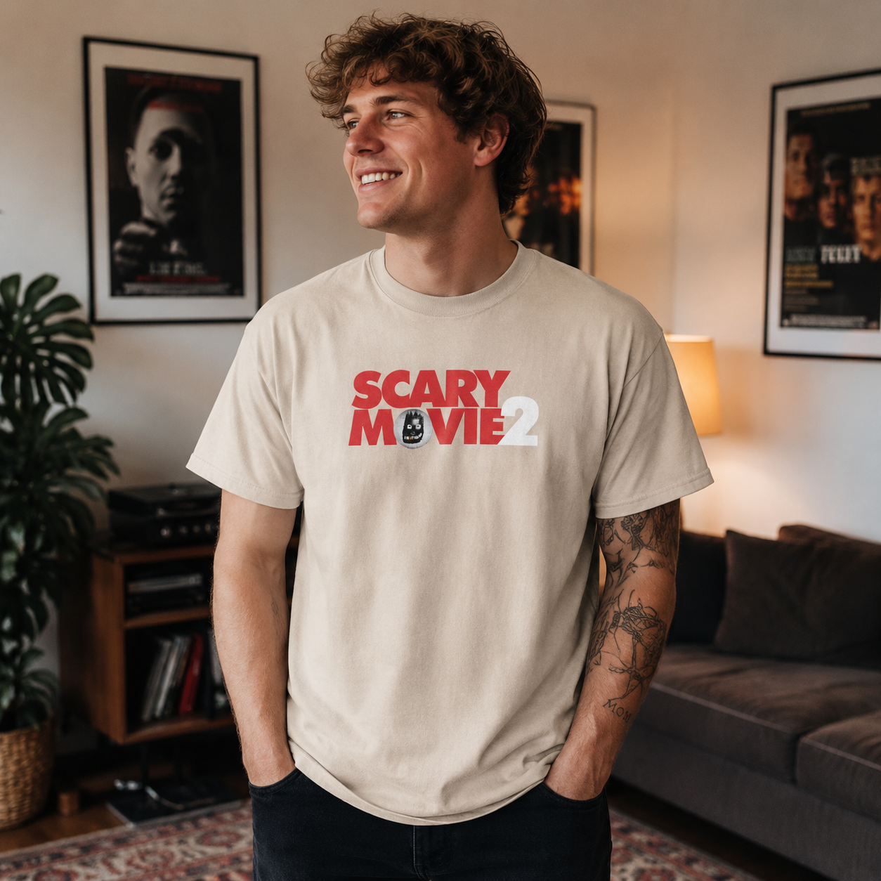 Male model wearing Scary Movie 2 Logo Sand T-Shirt in a cozy movie room with horror posters