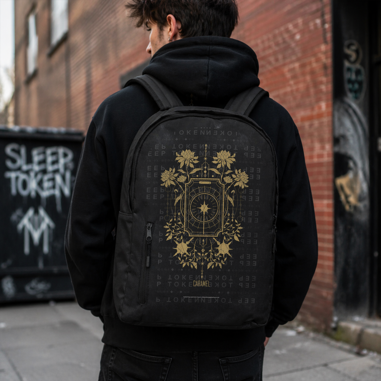 Male model wearing Sleep Token gold symbol backpack black rock band backpack lifestyle urban setting