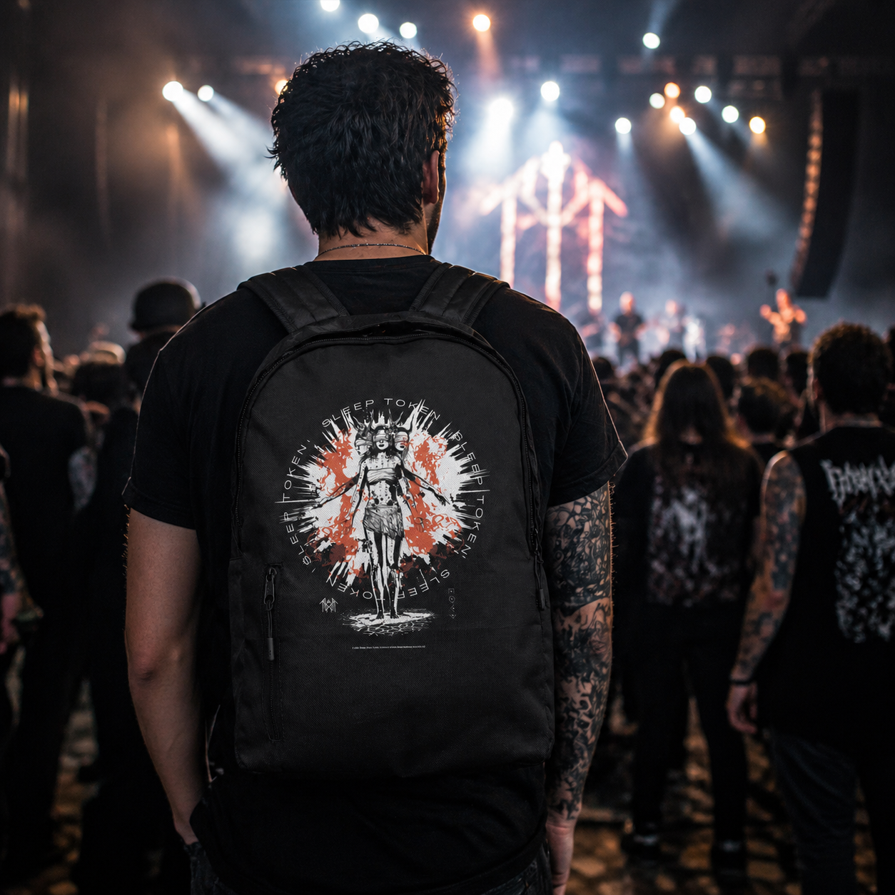 male model wearing Sleep Token Rain Down backpack at concert black band merch bag with red white graphic design in live music setting