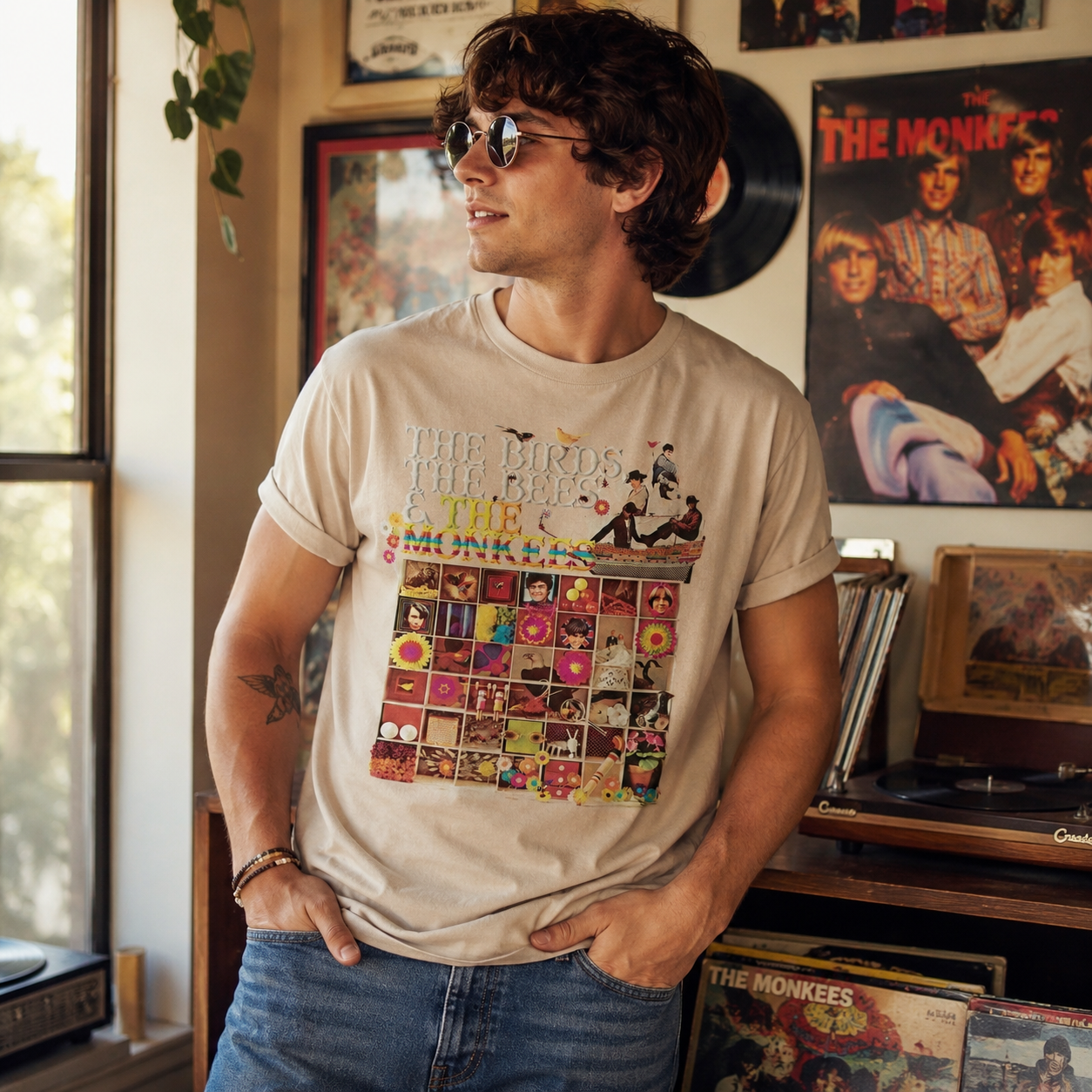 Male model wearing The Monkees Birds Bees t-shirt in a retro music room with vintage vinyl records and colorful 1960s pop rock decor