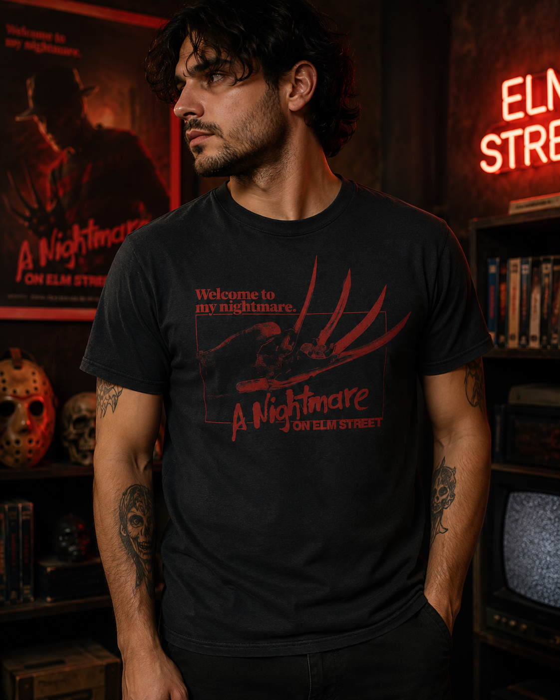 Male model wearing a Welcome to My Nightmare horror tee in a dark red-lit horror room with vintage slasher movie decor.